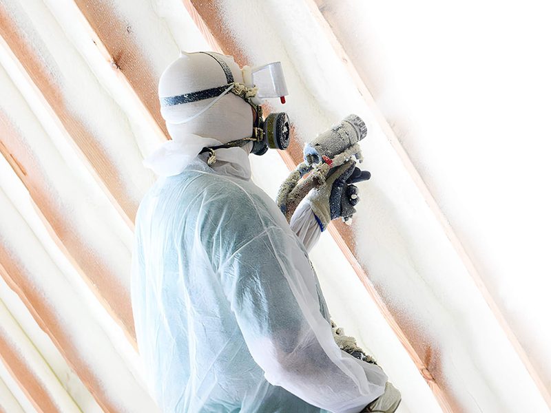 USA Spray Me technician applying spray foam insulation to a roof deck