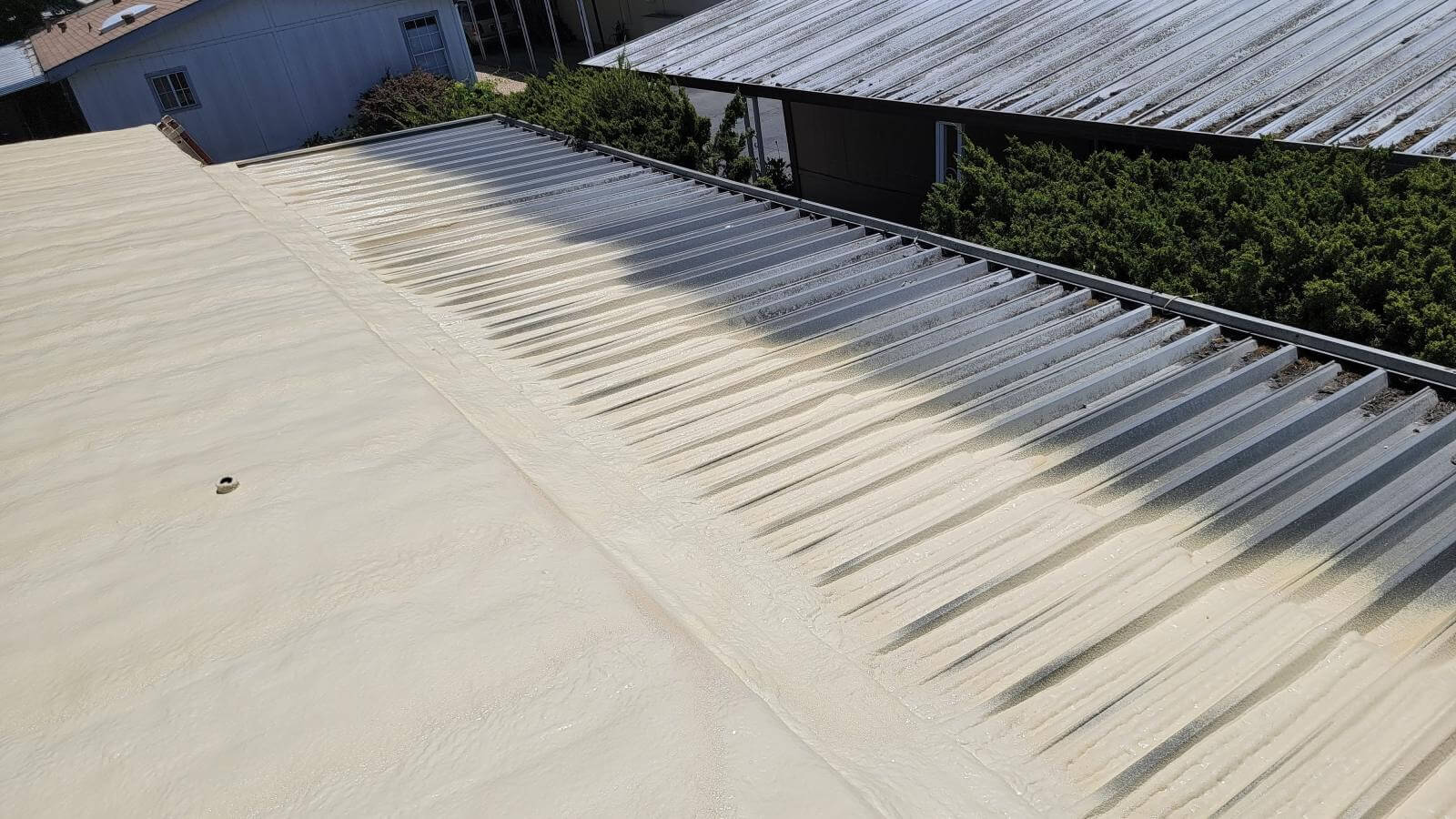 Foam roofing sloped to drain around rooftop equipment