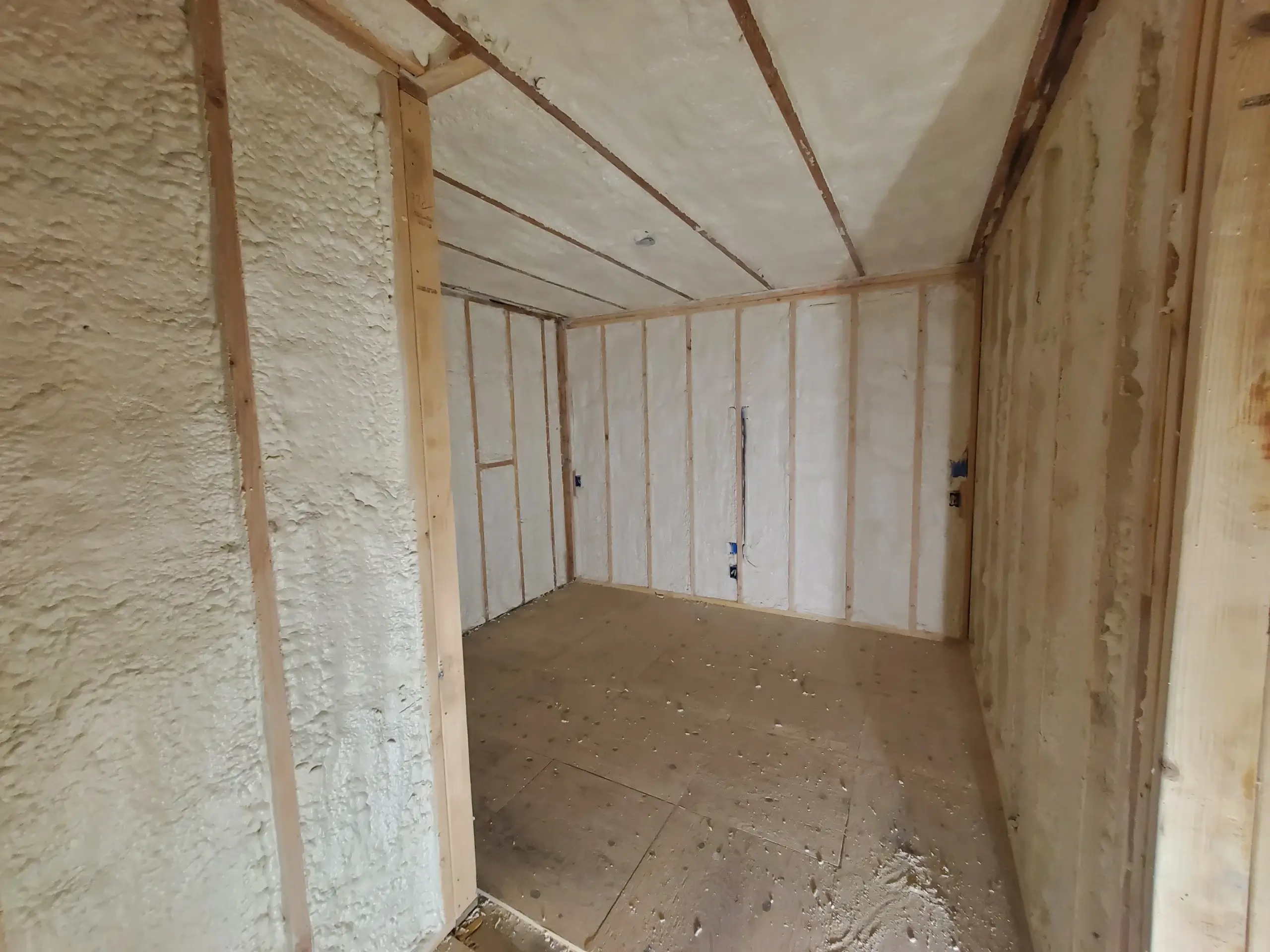 Technician applying spray foam insulation to a Bay Area attic roof deck